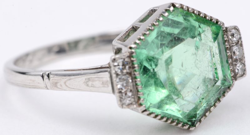 Een 18 karaats wit gouden art deco ring bezet met een centrale smaragd van ± 2 ct. en diamanten met een gezamenlijk gewicht van ± 0,18 ct. 1956.