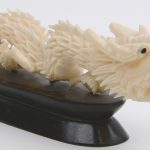 Een draak van fijn gesculpteerd ivoor. Chinees werk. Op houten sokkel. Begin XXe eeuw.