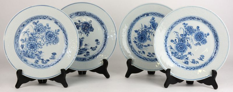 Een reeks van vier borden in van blauw en wit Chinees porselein met een decor van pioenen op het plat en een bianco sopra bianco-decor op de vleugel.