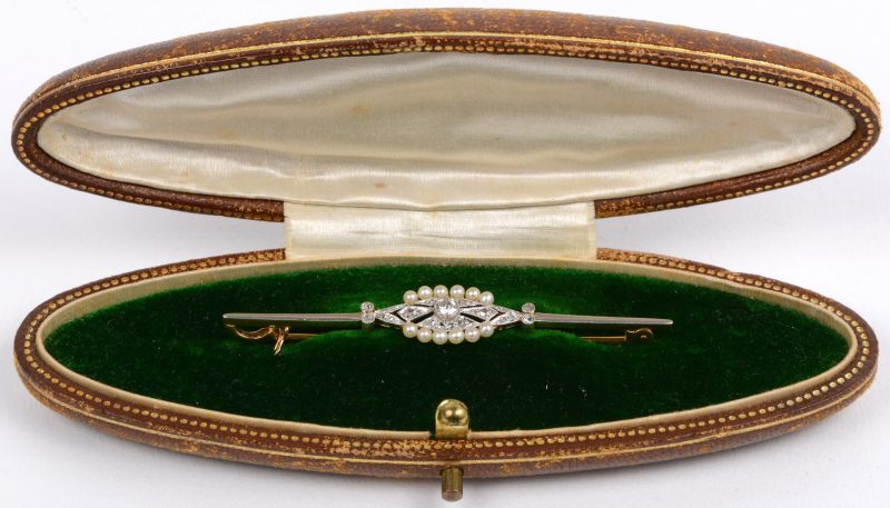 Een 18 karaats wit en geel gouden broche bezet met diamanten oude slijp met een gezamenlijk gewicht van ± 0,30 ct. en parels. In originele doos.