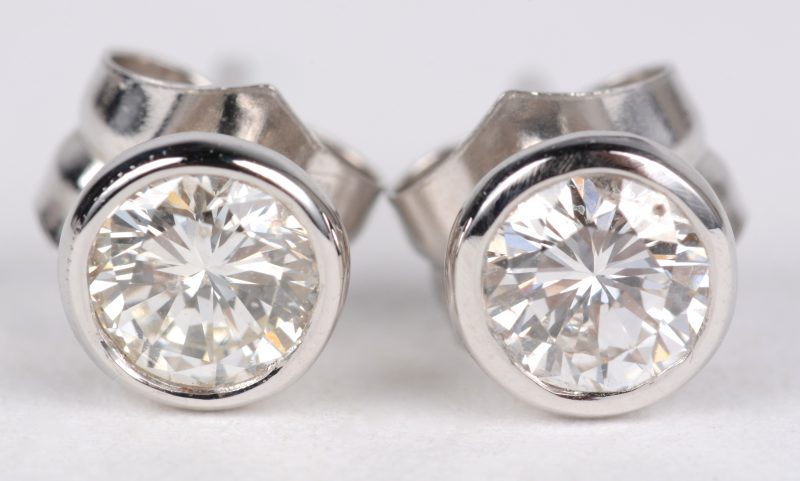 Een paar 18 karaats wit gouden oorbellen bezet met diamanten met een gezamenlijk gewicht van ± 0,74 ct.