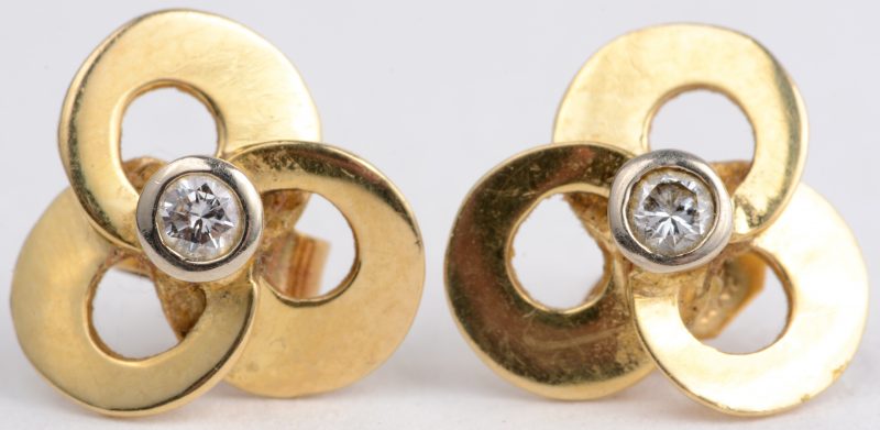Een paar 18 karaats geel gouden oorbellen bezet met diamanten met een gezamenlijk gewicht van ± 0,10 ct.