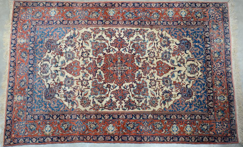 Een handgeknoopt Perzisch karpet van katoen en wol.