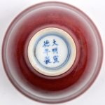 Een kopje van Chinees porselein met een sang-de-boeufglazuur.  Gemerkt met verwijzing naar Keizer Siuan-To.