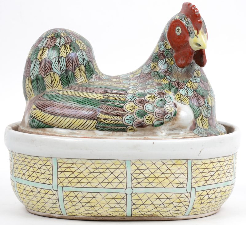Een bakschaal van meerkleurig porselein in de vorm van een kip.