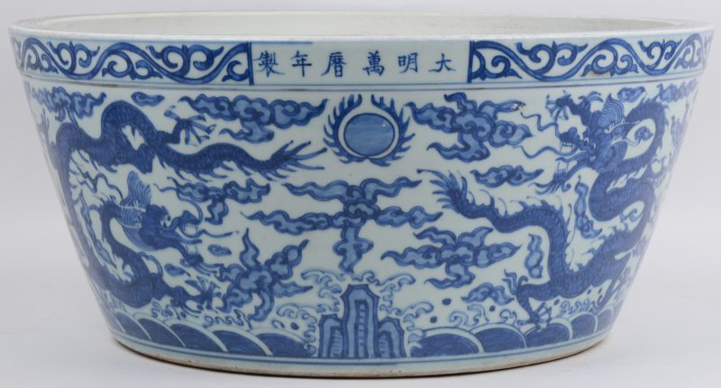 Een grote schaal van Chinees porselein met een blauw en wit decor van draken.