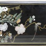 Een Chinese salontafel van zwartgelakt hout. Het bald versierd met een voorstelling van een vogel in een bloemenstruik van pietra dura onder glas.