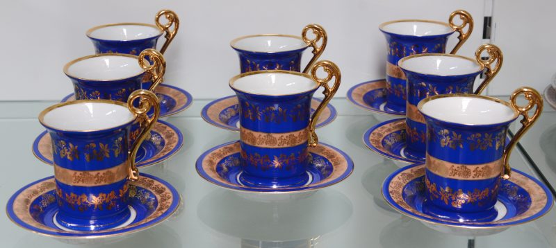 Een reeks van acht theekopjes en schoteltjes van blauw en verguld porselein in de geest van het Limogesporselein. Onderaan gemerkt.