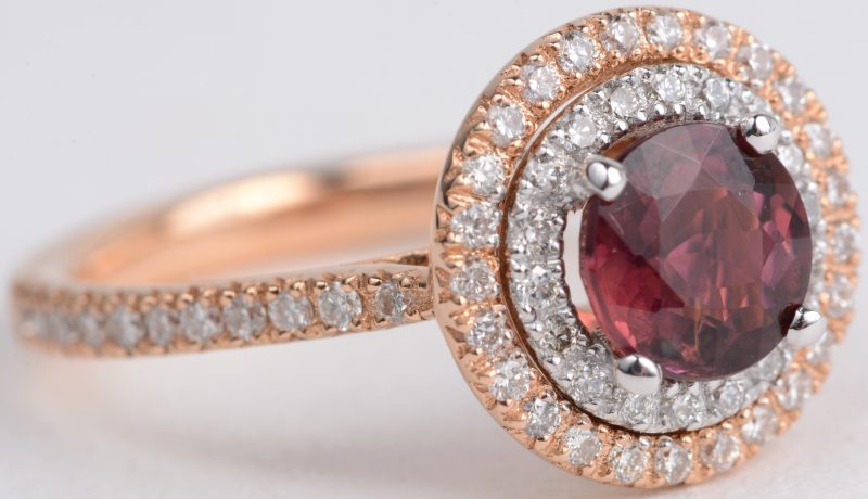 Een 18 karaats wit en roze gouden ring bezet met een centrale tourmalijn van ± 1,20 ct. en met diamanten met een gezamenlijk gewicht van ± 0,55 ct.