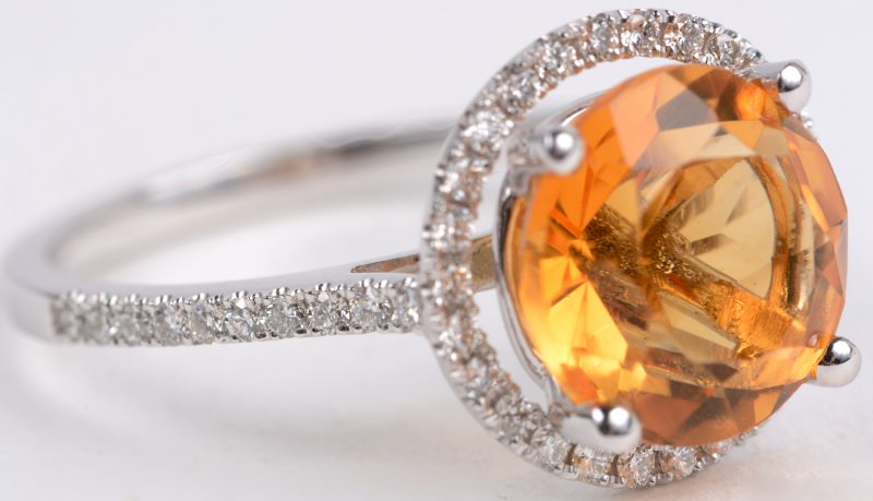 Een 18 karaats wit gouden ring bezet met een centrale citrine van ± 3,35 ct. en met diamanten met een gezamenlijk gewicht van ± 0,35 ct.