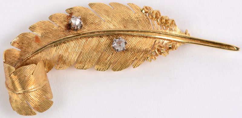 Een 18 karaats geel gouden bladvormige broche bezet met twee diamanten oude slijp met een gezamenlijk gewicht van ± 0,20 ct .