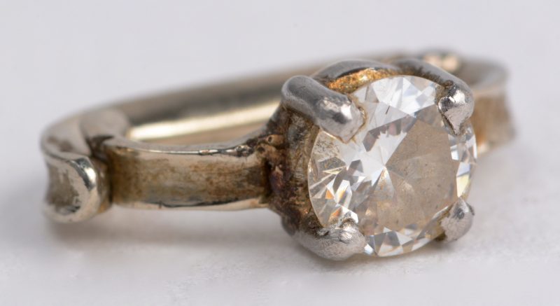 Een 18 karaats wit gouden clips bezet met één diamant van ± 0,20 ct.