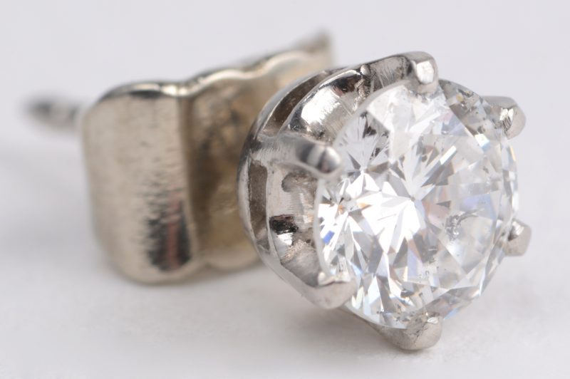 Een 18 karaats wit gouden oorbel bezet met één diamant van ± 0,50 ct.