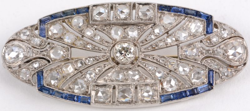 Een 18 karaats wit gouden art deco broche bezet met diamanten oude slijp en één centrale briljant met een gezamenlijk gewicht van ± 2 ct. en saffier baguetten met een gezamenlijk gewicht van ± 1 ct.
