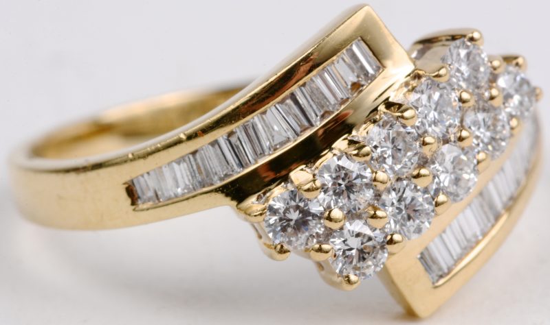 Een 18 karaats geel gouden ring bezet met briljanten en baguetten met een gezamenlijk gewicht van ± 1 ct.