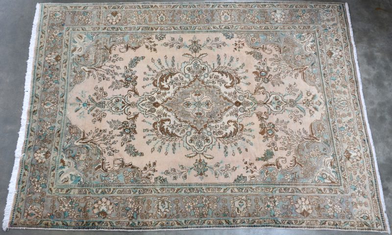 Een antiek Perzisch handgeknoopt wollen tapijt.
