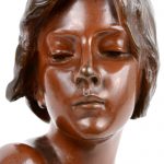“Seule”. Een bronzen buste met meerkleurig patina. Gesigneerd en met gieterijstempel.