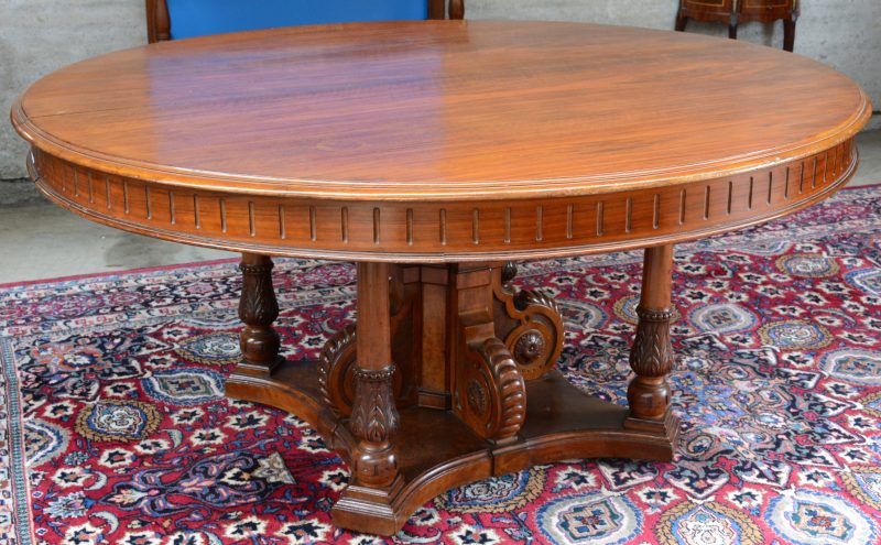 Een ovale tafel van mahoniehout met mooi gebeeldhouwde centrale poot  met vier zuiltjes.