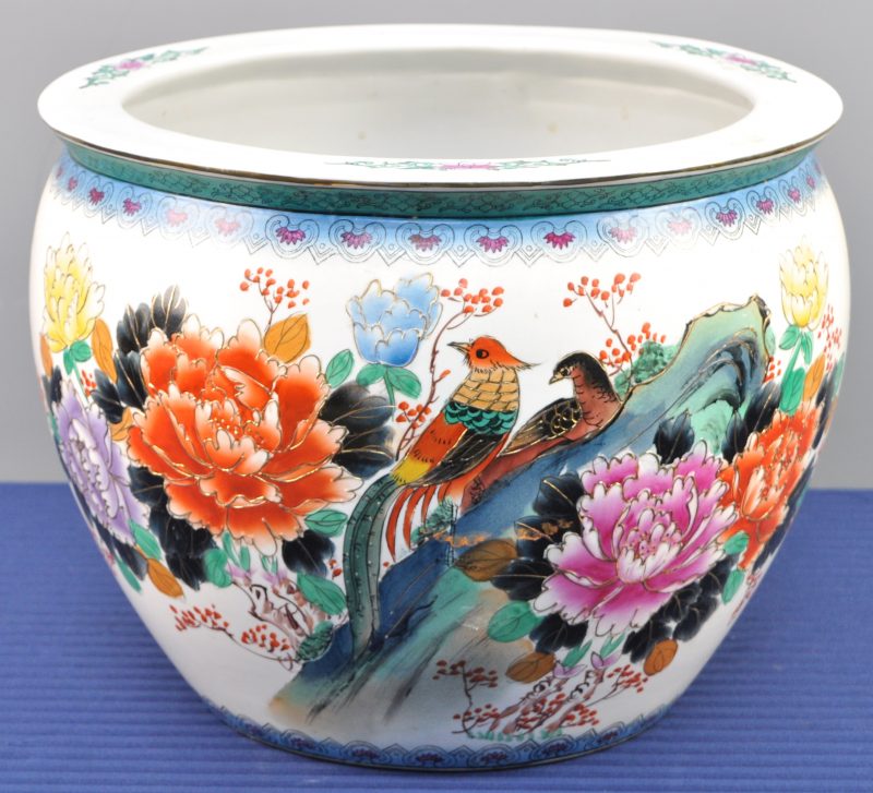 Een cachepot van Chinees porselein met een meerkleurig decor van bloemen en vogels en vissen binnenin.