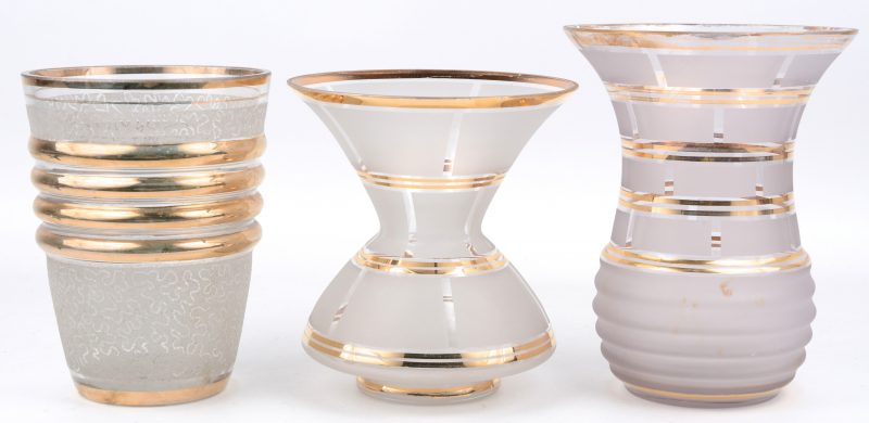 Een lot Booms glas, bestaande uit drie verschillende kleurloze vazen met gouden details.