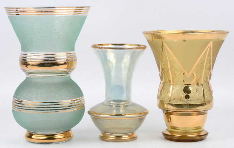 Een lot Booms glas, bestaande uit drie verschillende vazen met gouden details, waarvan een groen, een blauwe en een goudkleurige.