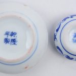 Een Chinese kalligrafische set, bestaande uit een waterbakje en een stempel van leisteen, een penseellegger, een verfbakje en een waterkommetje van porselein met een draak in het decor en een stempel van speksteen. In etui.
