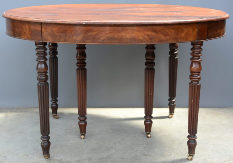 Een ovale mahoniehouten tafel, verlengbaar tot 3,5 m. Gecanneleerde poten.