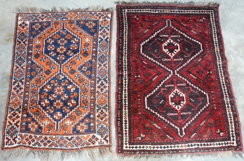Twee handgeknoopte Oosterse karpetjes van wol. Eén met slijtage.