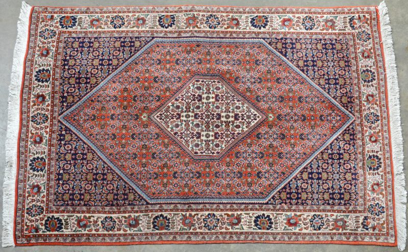Oosters tapijt van wol met een centraal geometrisch medaillon. Handgeknoopt.