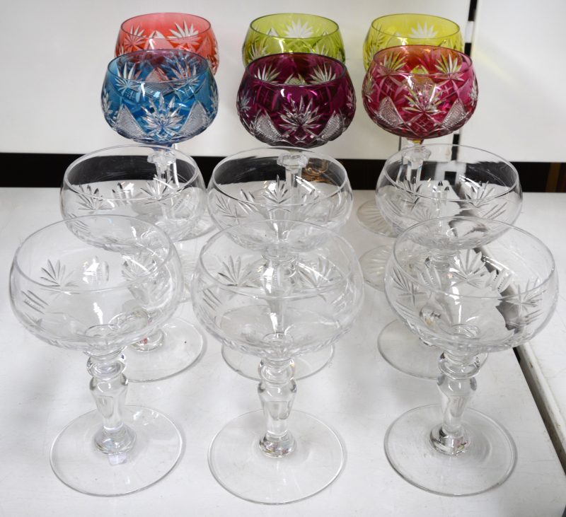 Een lot glazen van geslepen kristal, bestaande uit zes kleurloze champagnecoupes en zes gekleurde glazen.