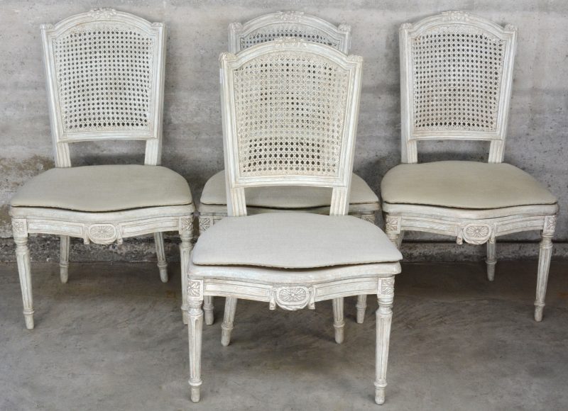 Een reeks van vier stoelen van grijsgepatineerd hout in Lodewijk XVI-stijl.