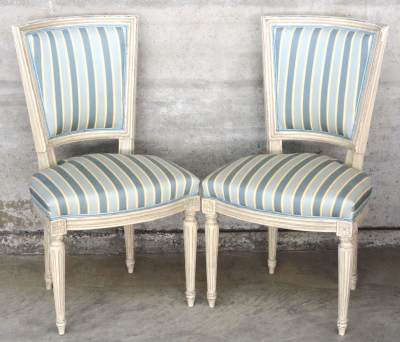 Een paar stoelen van witgepatineerd hout in Lodewijk XVI-inspiratie.