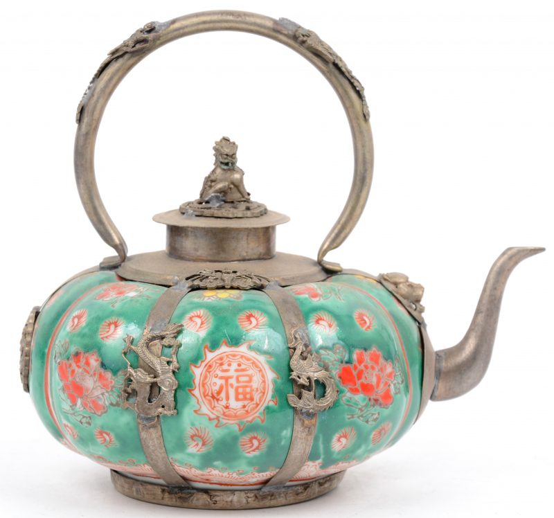 Een pompoenvormig theepotje van Chinees porselein met een decor van bloemen op groene fond en met koperen monturen.