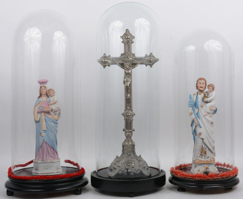 Een lot van drie stolpen, waarbij twee met een heiligenbeeld van biscuit en één met een tinnen kruisbeeld.