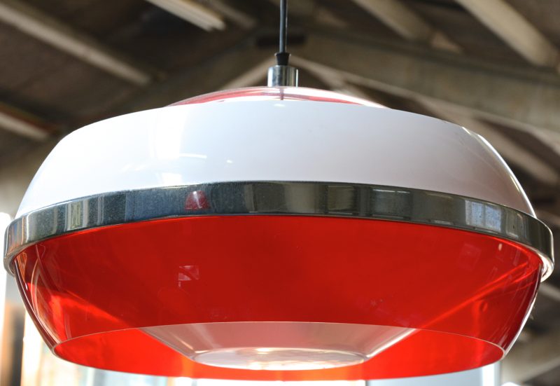 Een rode en witte kunststoffen hanglamp.