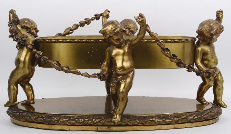 Een milieu-de-table van verguld brons, gedragen door vier putti met guirlandes. Eén guirlande te herstellen.