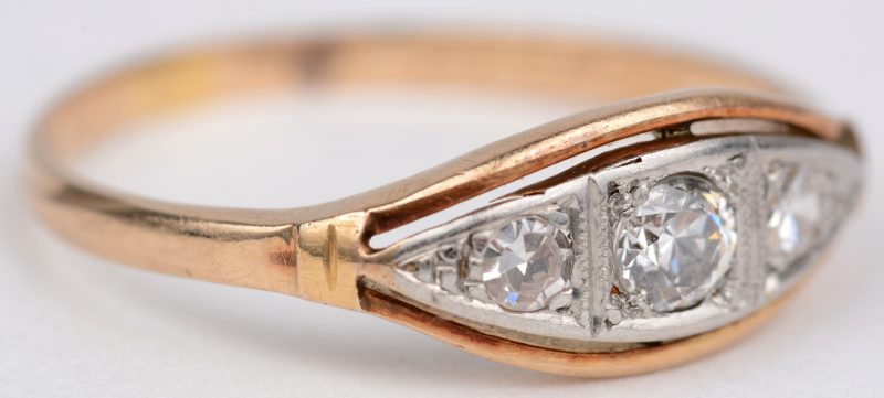 Een 18 karaats wit en geel gouden ring bezet met diamanten met een gezamenlijk gewicht van ± 0,30 ct.