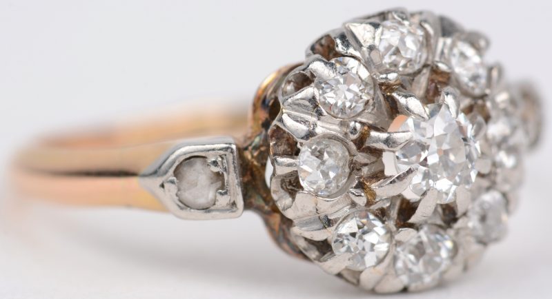 Een 18 karaats wit en geel gouden ring bezet diamanten met een gezamenlijk gewicht van ± 0,50 ct.