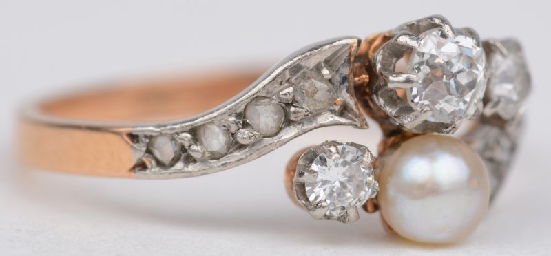 “Toi et moi”. Een 18 karaats wit en geel gouden ring bezet met diamanten met een gezamenlijk gewicht van ± 0,40 ct. en een parel.