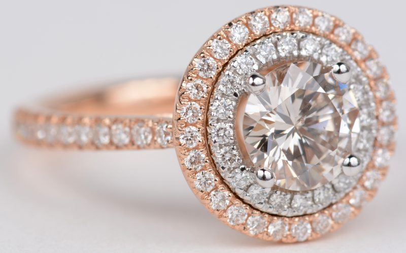 Een 18 karaats wit en roze gouden ring bezet met diamanten met een gezamenlijk gewicht van ± 0,64 ct. en een centrale diamant van ± 1,05 ct.