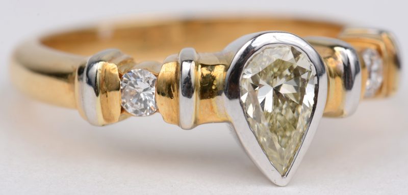 Een 18 karaats wit en geel gouden ring bezet met diamanten met een gezamenlijk gewicht van ± 0,20 ct. en een centrale diamant van ± 0,80 ct.
