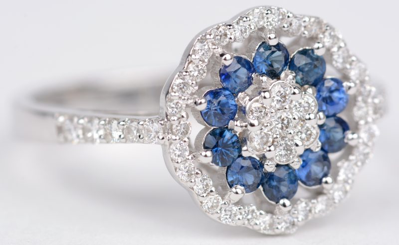 Een 18 karaats wit gouden ring bezet met diamanten in bloemvormige potjes gezet met een gezamenlijk gewicht van ± 0,90 ct.