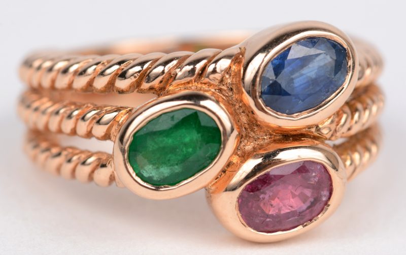 Een 18 karaats geel gouden geweven ring bezet met smaragd, saffier en robijn met een gezamenlijk gewicht van ± 1,50 ct.