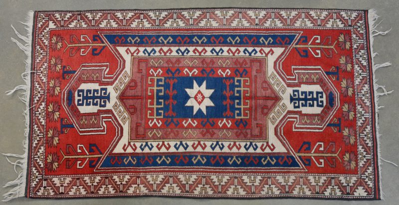 Een Oosters handgeknoopt wollen tapijt. Kazak.