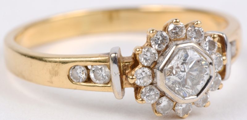 Een 18 karaats wit en geel gouden ring bezet met diamanten met een gezamenlijk gewicht van ± 0,70 ct.