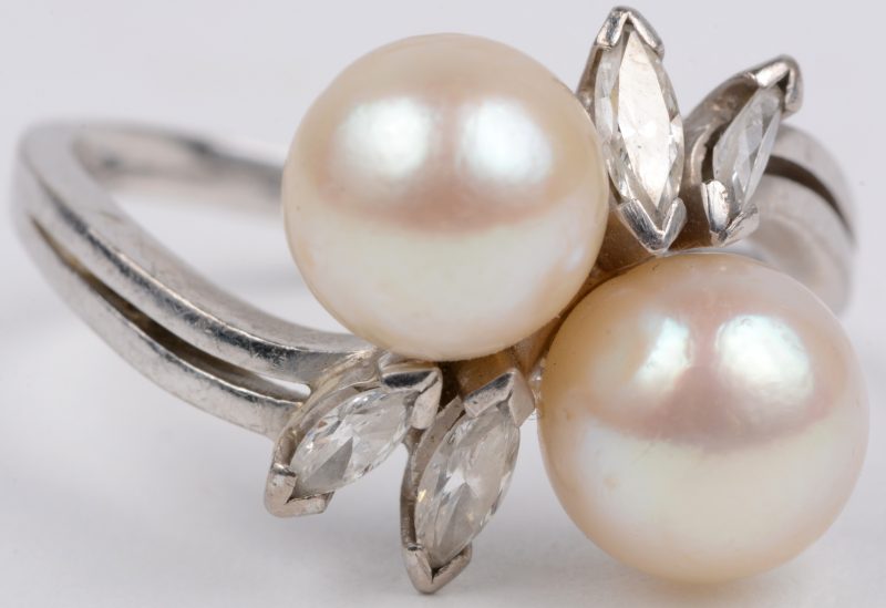 “Toi et Moi”. Een 18 karaats wit gouden ring bezet met diamanten in markies geslepen met een gezamenlijk gewicht van ± 0,50 ct. en twee parels.