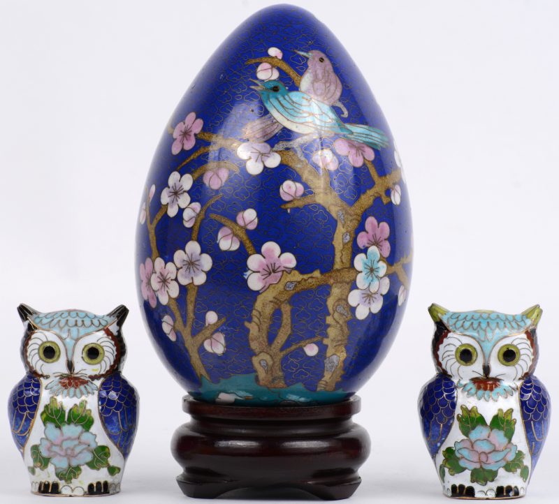 Een lot voorwerpen van cloisonné op koper, bestaande uit twee uiltjes en een ei, versierd met bloesems in het decor.