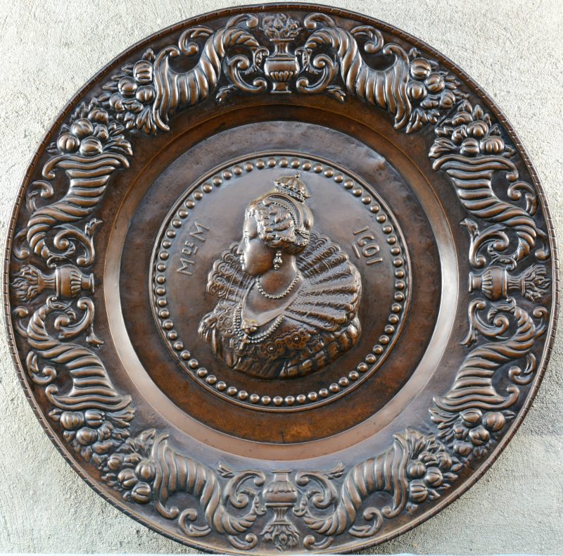 “Koningin Isabella”. Een ronde koperen plaquette.