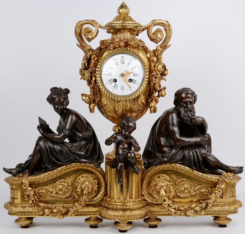 Een schouwpendule van verguld brons in barokke stijl, getooid met drie allegorische personages en het uurwerk in een siervaas.