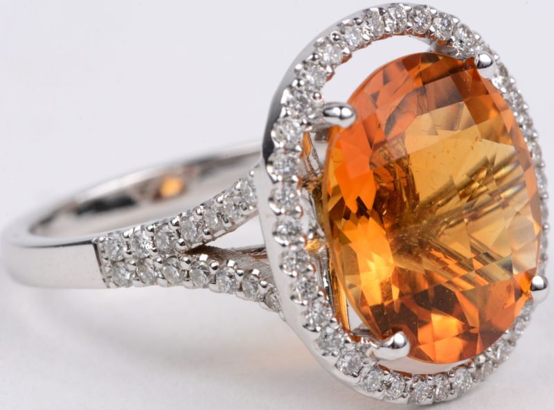 Een 18 karaats wit gouden ring bezet diamanten met een gezamenlijk gewicht van ± 0,65 ct. en een in princess geslepen citrine van ± 8,45 ct.